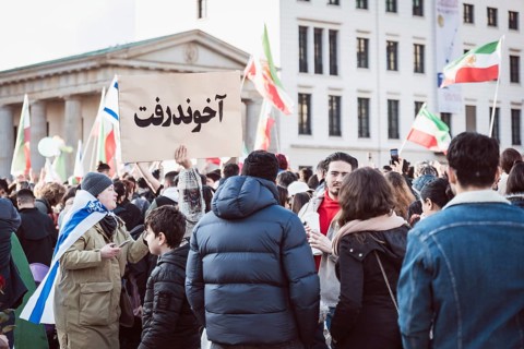 A person holds up a sign with the inscription The Mullah Went during the demonstration by exiled