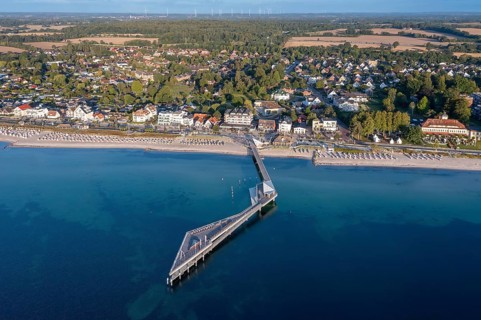Aerial view over Seebrücke, pier and sandy beach at seaside resort Haffkrug along the Baltic Sea,