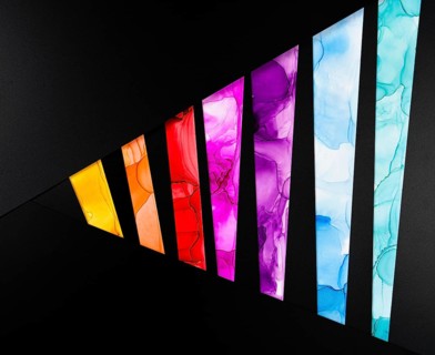 A vibrant geometric pattern with colorful segments on a black background of paper. Each segment