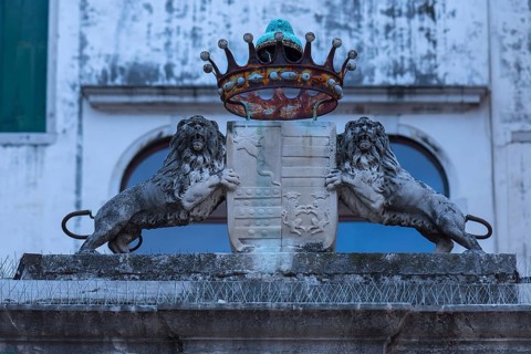 Two lion sculptures with a coat of arms and crown in front of a palazzo, Venice, Veneto, Italy