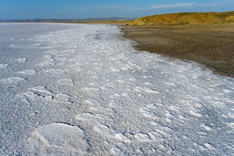 Texturally rich salt flat on the shore of a lake that ends on the horizon far away, Salt Lake, Tuz