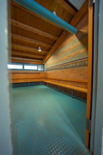 View through an open door into a changing room with brick walls and wooden ceiling, Schlehengäu
