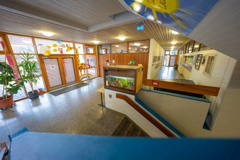 Inviting entrance area with colorful decorations and wooden paneling, Schlehengäu Grund Schule
