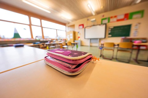 A pencil case is lying on a table in the classroom, window in the background, Schlehengäu Grund