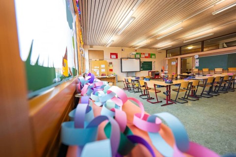 Paper chains hanging in a classroom with a view of windows and rows of seats, Schlehengäu Grund