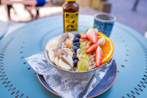 A delicious and healthy breakfast with fresh fruits such as strawberries and bananas on a café