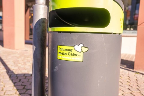 A trash can with city cleanliness sticker on a sunny day in public spaces, Calw, Calw district,