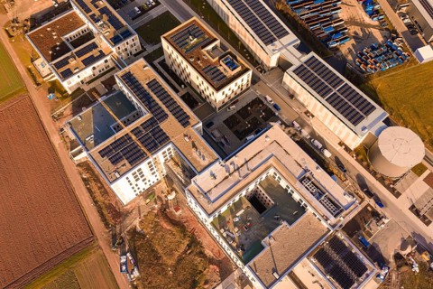 Bird's eye view of building roofs with solar panels and industrial structure, new hospital at Calw