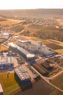Aerial view of urban landscape in morning light with buildings, parks and fields, new hospital at
