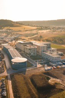 Modern buildings in an industrial area surrounded by fields at sunset, new hospital at Calw Health