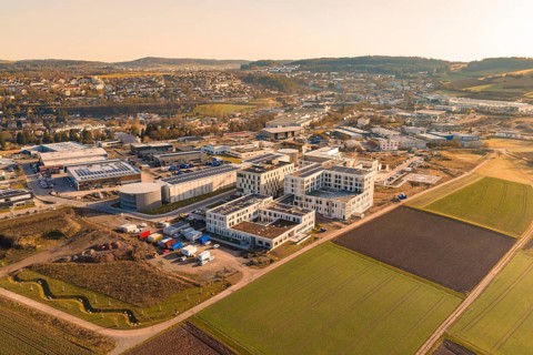 Extensive landscape with modern buildings and fields in the light of a clear morning, new hospital