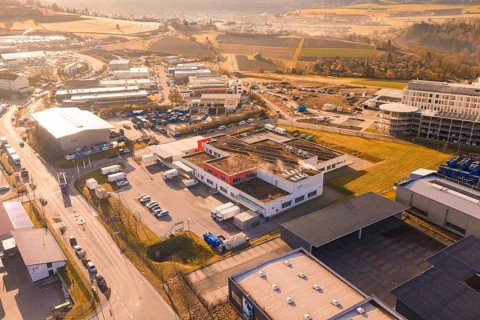 Industrial area with various warehouses and vehicles in an urban environment, new hospital at the