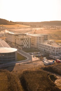 Modern architecture in rural surroundings with small fields and rolling hills, new hospital at the