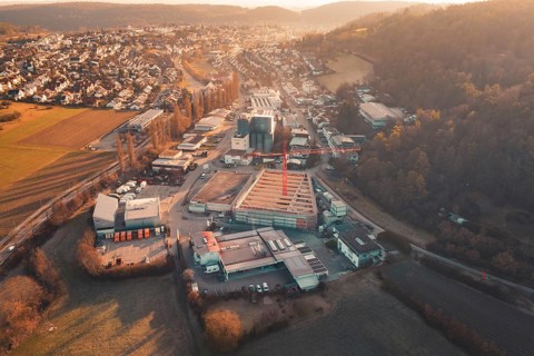Extensive urban scene with construction crane and surrounding buildings in hilly landscape and