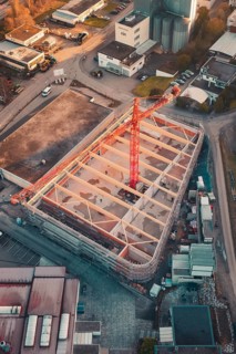 Bird's eye view of a construction site with visible building structure and construction crane at