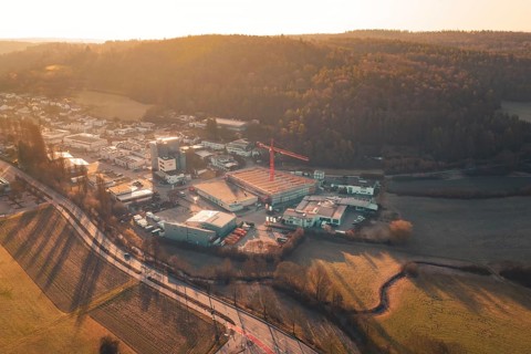 Landscape scene at sunset with road, urban area and hills in the background, Neubau Rewe,