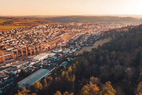 Panoramic view of a town adjacent to dense forest under evening sun, Aidlingen, Böblingen District,