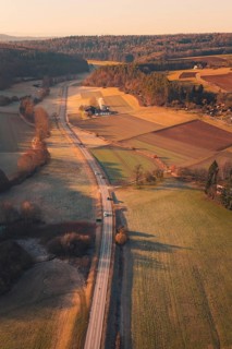 A country road winding through fields and hills in warm sunlight, Aidlingen, Böblingen District,