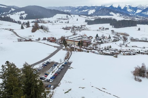 Snowy mountain village surrounded by hills and roads from a bird's eye view, specialist clinic for
