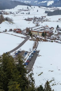Snowy village with parking lots and picturesque mountains viewed from afar, specialist clinic for