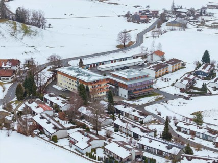 Snowy village with views of roofs and roads from above, specialist clinic for psychosomatics and
