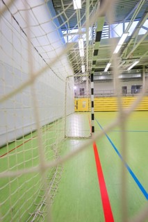 A handball goal and net in a large empty sports hall from a side view, Handball, Calw, Germany