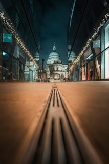 Central view of cathedral at night through symmetrical modern facades, London, United Kingdom
