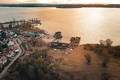 Extensive view with a lake, traditional stilt houses and warm sunset light, stilt houses