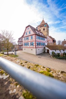 View of half-timbered houses and church tower with cobblestones and blue sky, Ötisheim, Enzkreis,