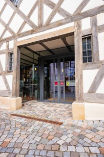 Entrance of a charming half-timbered house with glass front and cobblestones in traditional