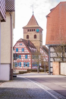 Street scene with view of half-timbered house and church tower with clock, Ötisheim, Enzkreis,