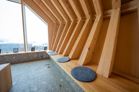 Modern interior with wooden benches and view of the landscape through windows, Sinnraum, Oberreute,