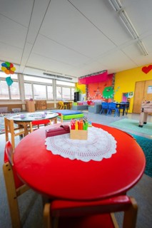 Creative environment in a kindergarten with round table and colored pencils, colorful decoration,