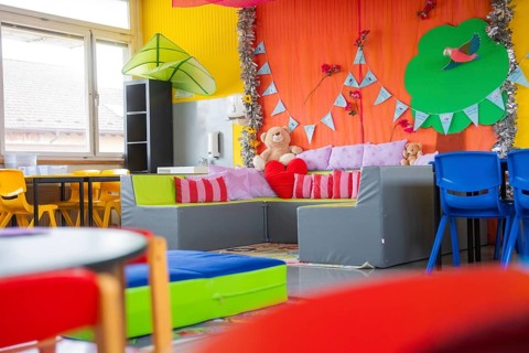 Child-friendly seating area with cuddly toys and colorful pillows, decorative elements in the