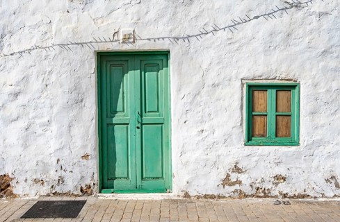 Typical white house with turquoise wooden door and window in an alley, Teguise, Lanzarote, Canary