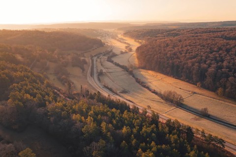 Wooded valley view at sunset with a road snaking through the rolling hills, Gechingen, Calw County,