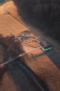Wastewater treatment plant and delicate light patterns through trees and fields at dawn, Gechingen,
