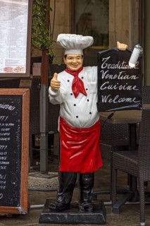 Chef as an advertising character with an offer in front of a restaurant, Venice, Veneto, Italy
