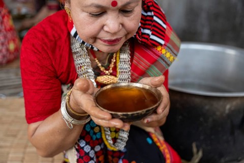 A Mising tribal woman having traditional rice beer 'Aapong' during Ali-Aye-Ligang festival in