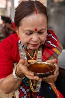 A Mising tribal woman having traditional rice beer 'Aapong' during Ali-Aye-Ligang festival in