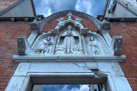 Entrance gate with the mantle Madonna flanked by saints, Venice, Veneto, Italy