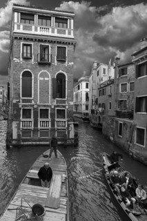 Historic Palazzo Tetta, on the canal, gondola with tourists and workboat, black and white, Venice,