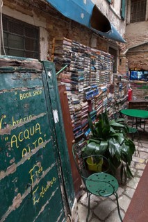 Stacked books on a wall after flood damage in a bookstore, Venice, Veneto, Italy