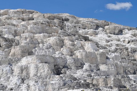 White, layered volcanic deposits under blue sky, Yellowstone National Park, Wyoming, USA