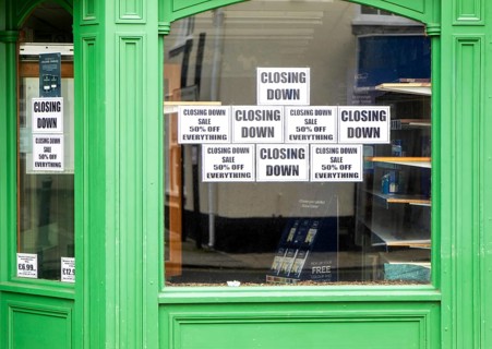 Shop window signs with empty shelves closing down sale, Beccles, Suffolk, England, UK