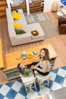 Happy mother and toddler boy sharing a morning meal at a kitchen island, creating a tender moment
