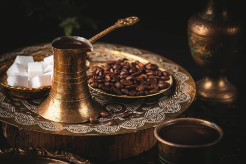 Traditional oriental scene with golden coffee pot and sugar cubes on decorative tray