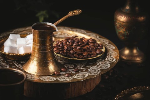 Oriental coffee scene with golden pot and sugar cubes served on a decorated tray