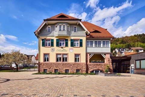 Town hall, commercial building, façade with windows, shutters and façade painting, hipped roof,