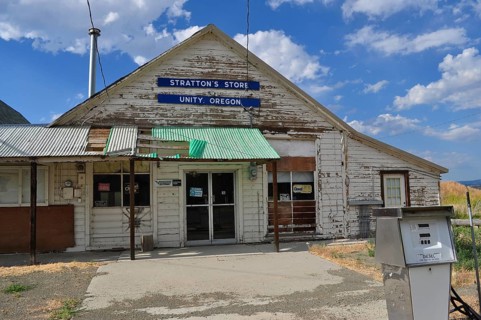 Close-up of a white wooden building, Stratton's Store, with signs and weathered paint, Unity,